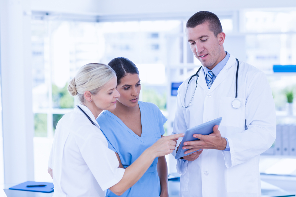 Doctors looking together at tablet in medical office